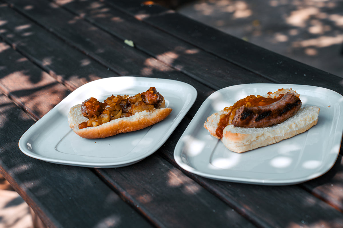 Boerewors rolls served on the white plates at an outdoor table